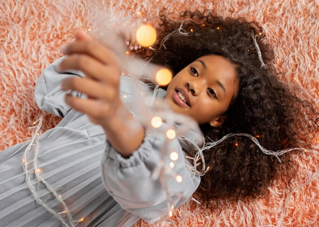 Fille de coup moyen posant avec des lumières