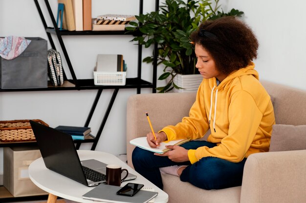 Fille de coup moyen en prenant des notes