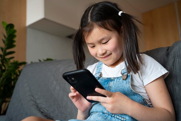 Fille de coup moyen avec téléphone