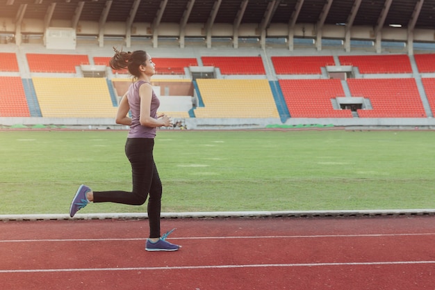 Fille courir sur une piste d&#39;athlétisme