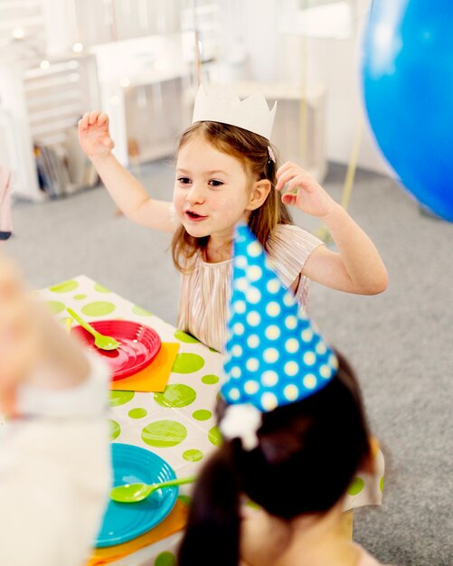 Fille en couronne de papier montrant des grimaces