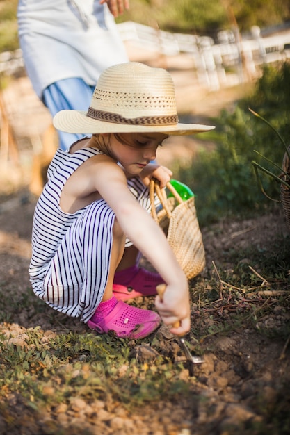 Fille creusant le sol avec une truelle