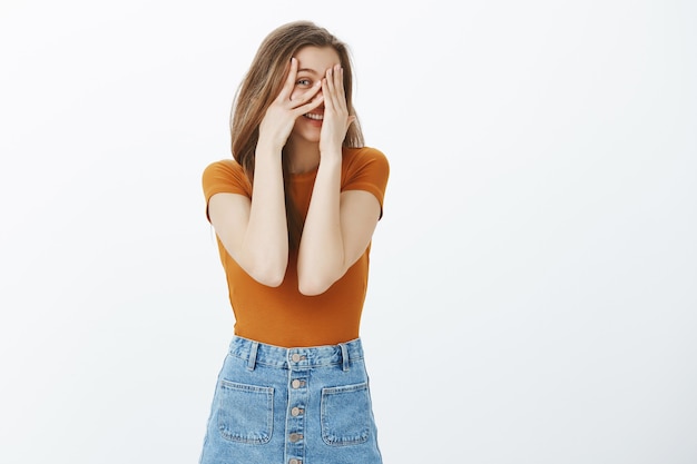 Une fille curieuse regarde entre les doigts, veut savoir ce qui se passe