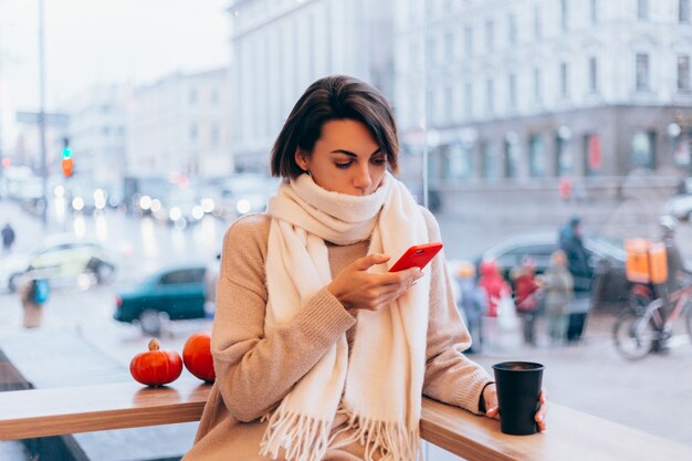 Une fille dans un café confortable se réchauffe avec une tasse de café chaud