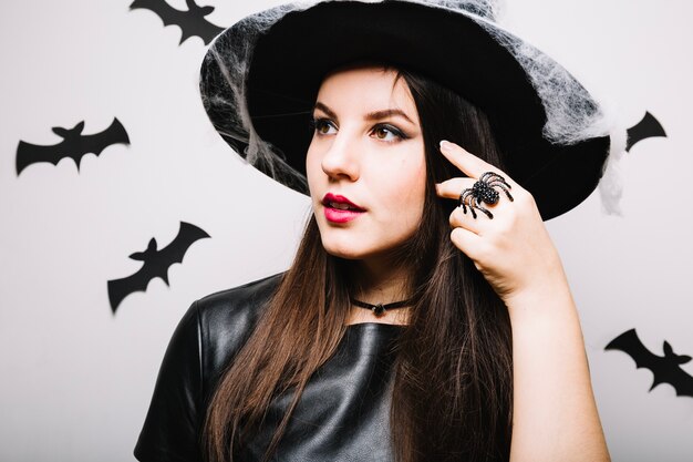 Fille dans le chapeau de Halloween en détournant les yeux