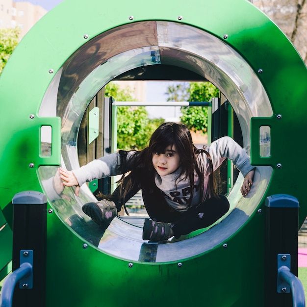 Fille dans le tube de terrain de jeu