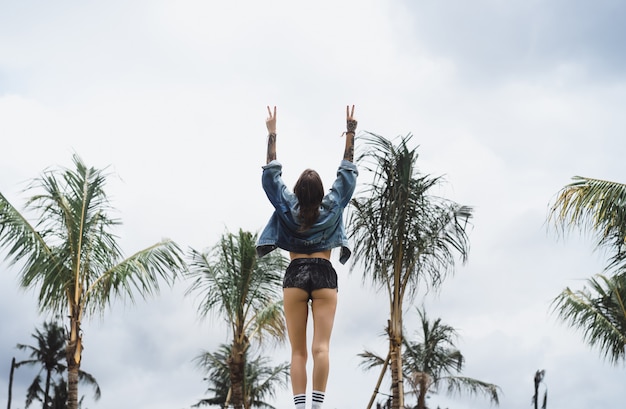 fille dans une veste en jean dans un endroit tropical