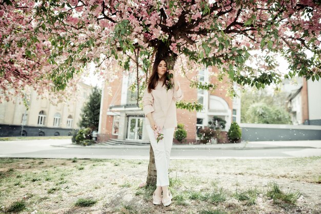 Fille, debout, près, sakura, bâtiment