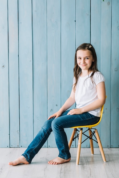 Fille décontractée assis sur une chaise