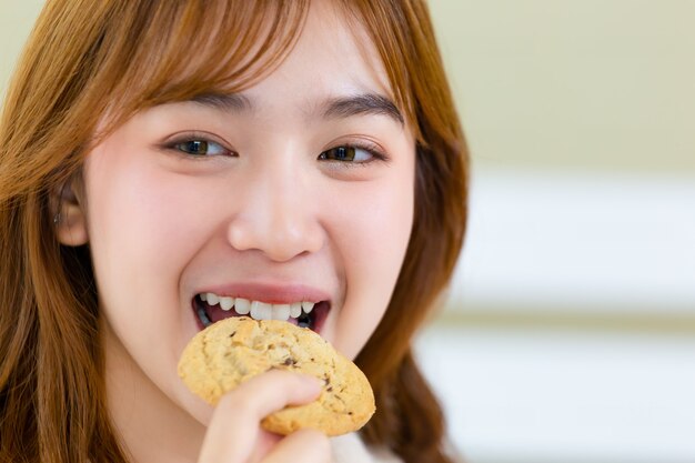 La fille et déguste de délicieux biscuits gastronomiques