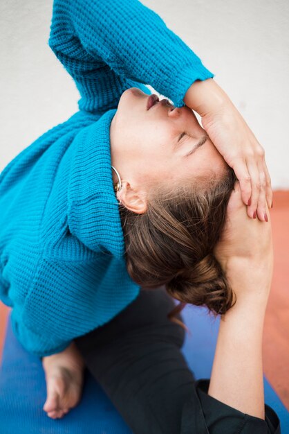 Une fille détendue pratiquant le yoga à la maison.