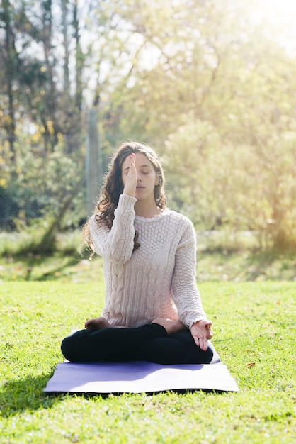 Photo gratuite fille détendue, pratiquant le yoga en plein air