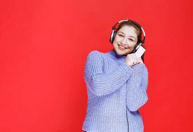 Fille Dj avec un casque présentant sa carte de visite.