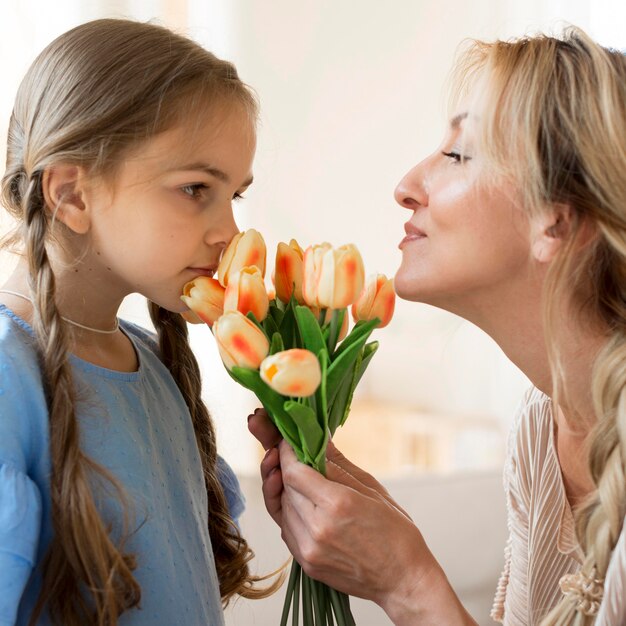 Fille donnant mère bouquet de fleurs comme cadeau