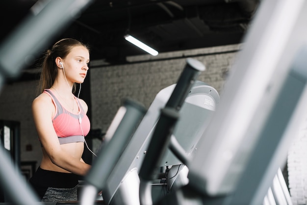 Fille écoutant de la musique au gymnase