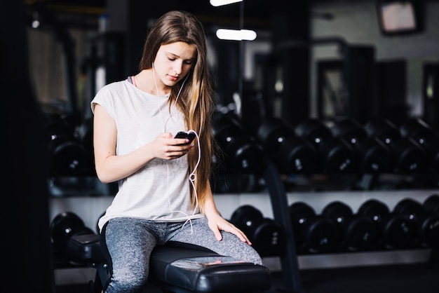 Fille écoutant de la musique dans la salle de gym