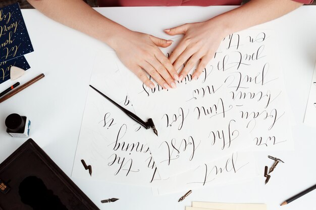 Fille écrit la calligraphie sur les cartes postales. Conception d'art. Au dessus de.