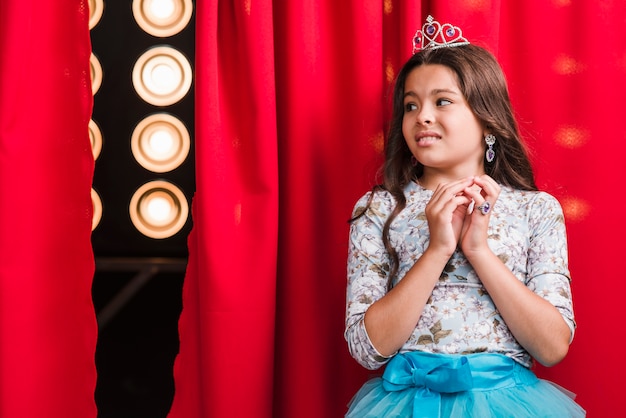 Fille effrayée debout dans les coulisses