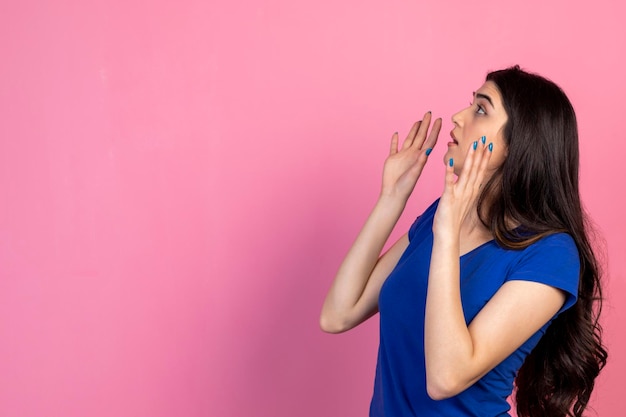 Une fille effrayée lève les mains et ne sait pas quoi faire Photo de haute qualité