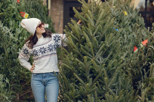 Fille élégante achète un arbre de Noël.