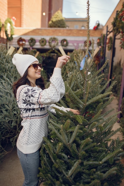 Photo gratuite fille élégante achète un arbre de noël.