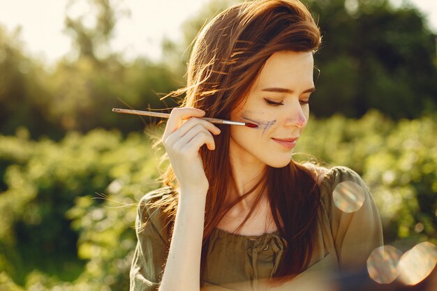 Fille élégante et belle peinture dans un champ