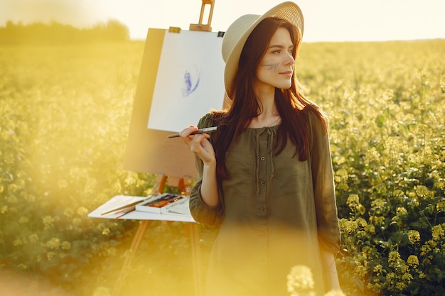 Fille élégante et belle peinture dans un champ