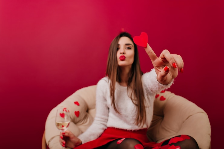 Photo gratuit fille élégante avec des confettis coeur posant avec l'expression du visage embrassant