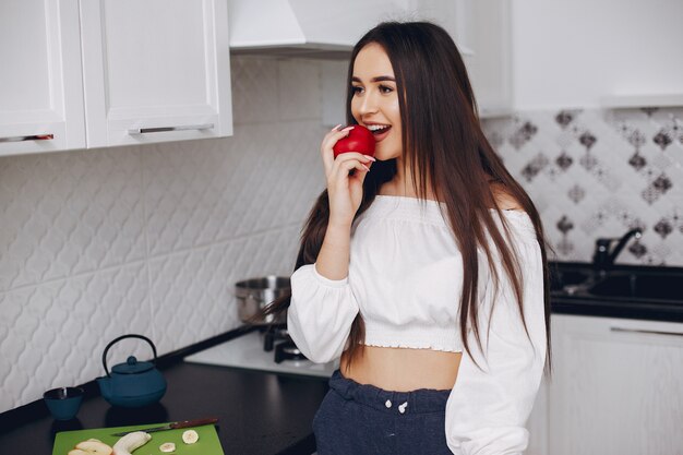 Fille élégante dans une cuisine avec des fruits