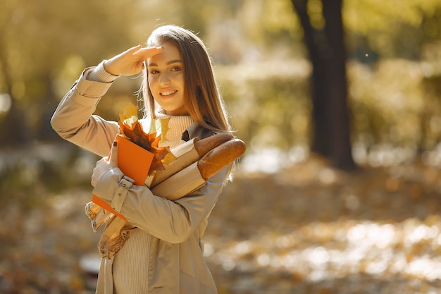 Fille élégante et élégante dans un parc en automne