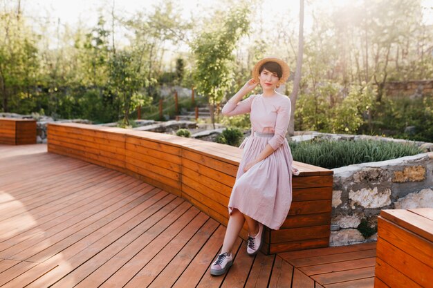 Fille élégante mince avec une tenue à l'ancienne reposant dans le parc sur une nature incroyable