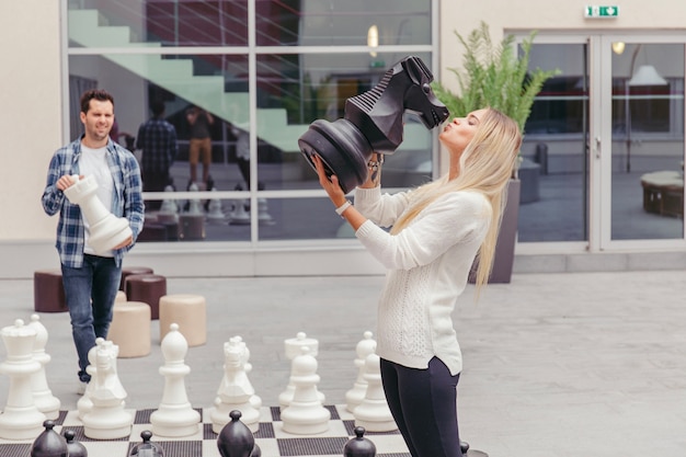 Fille embrassant le cheval d&#39;échecs par échiquier