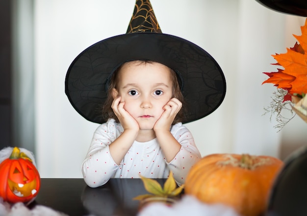 Fille Enfant Drôle En Costume De Sorcière Pour Halloween. Photo Premium