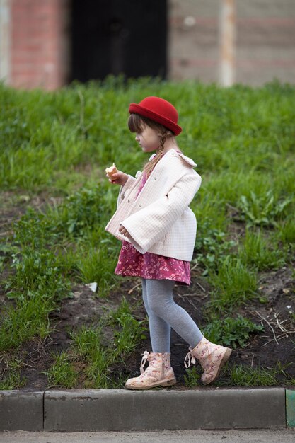 Fille enfant avec des nattes au chapeau mangeant de la crème glacée et des promenades