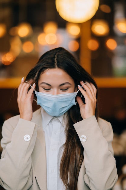 Fille en enlève son masque médical de protection