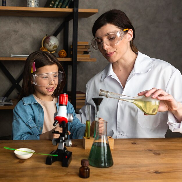 Fille et enseignante faisant des expériences scientifiques