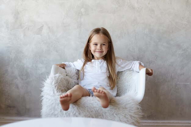 La fille est assise dans le salon