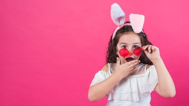 Fille étonnée dans les oreilles de lapin