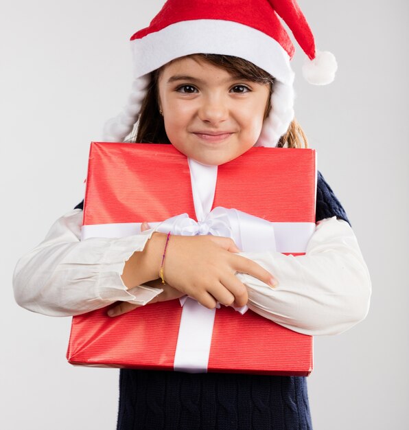 Fille étreignant un cadeau rouge