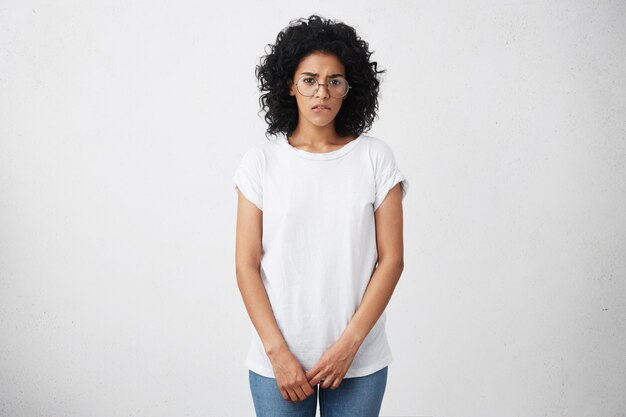 Fille étudiante afro-américaine timide et timide portant des lunettes