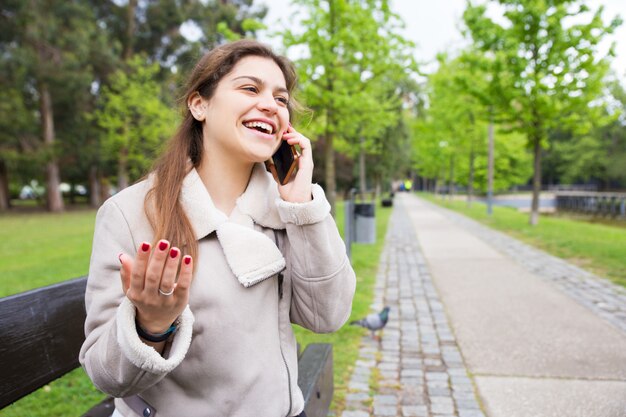 Fille étudiante heureuse excitée avec une conversation téléphonique drôle