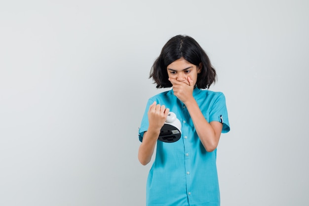 Photo gratuite fille étudiante regardant horloge en chemise bleue et à la recherche de stress