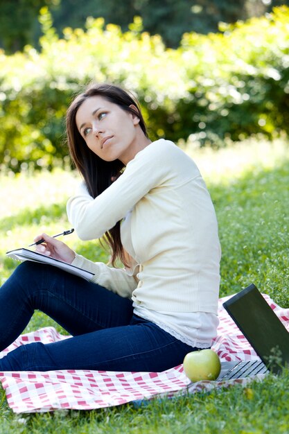 Fille étudie dans le parc verdoyant