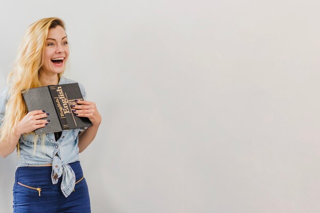 Fille excitée posant avec un livre