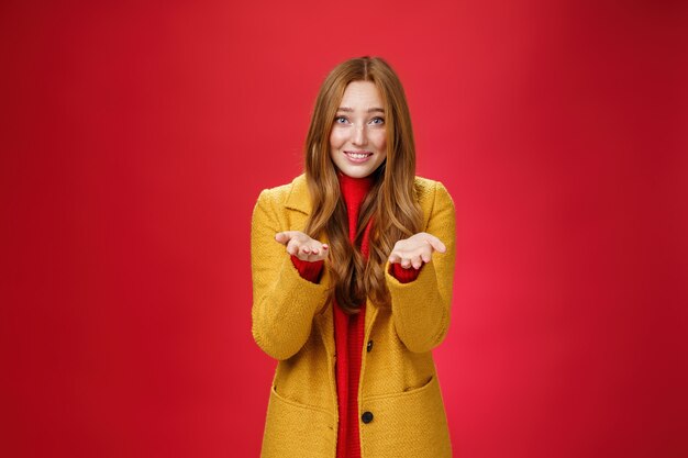 Fille à l'expression tendre et attentionnée souriante tendant les mains vers l'avant pour remercier ou pointer du doigt quelqu'un qui ressent une admiration spéciale remerciant son partenaire pour son soutien, confessant son amour et sa sympathie.