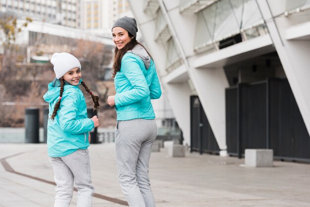 Fille de faible angle avec maman en cours d'exécution