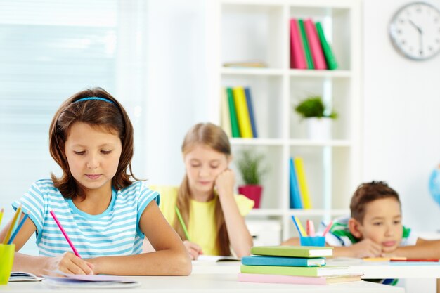 Fille à faire leurs devoirs assis à son bureau