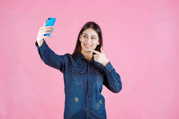 Fille faisant un appel vidéo ou prenant des selfies