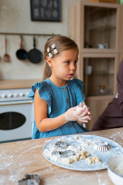 Fille faisant la cuisine dans la cuisine plan moyen