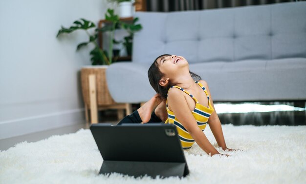 Fille faisant du yoga dans la chambre sur un tapis blanc. Mise au point sélective.